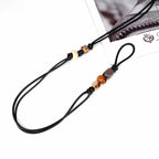 Close up of hand knotted black wax cord featuring colorful resin beads and thin adjustable tie