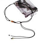 Close up of hand knotted black wax cord featuring colorful resin beads and thin adjustable tie