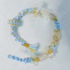 Floral inspiration graphic showing blue hydrangeas and handmade sky blue woven bracelet