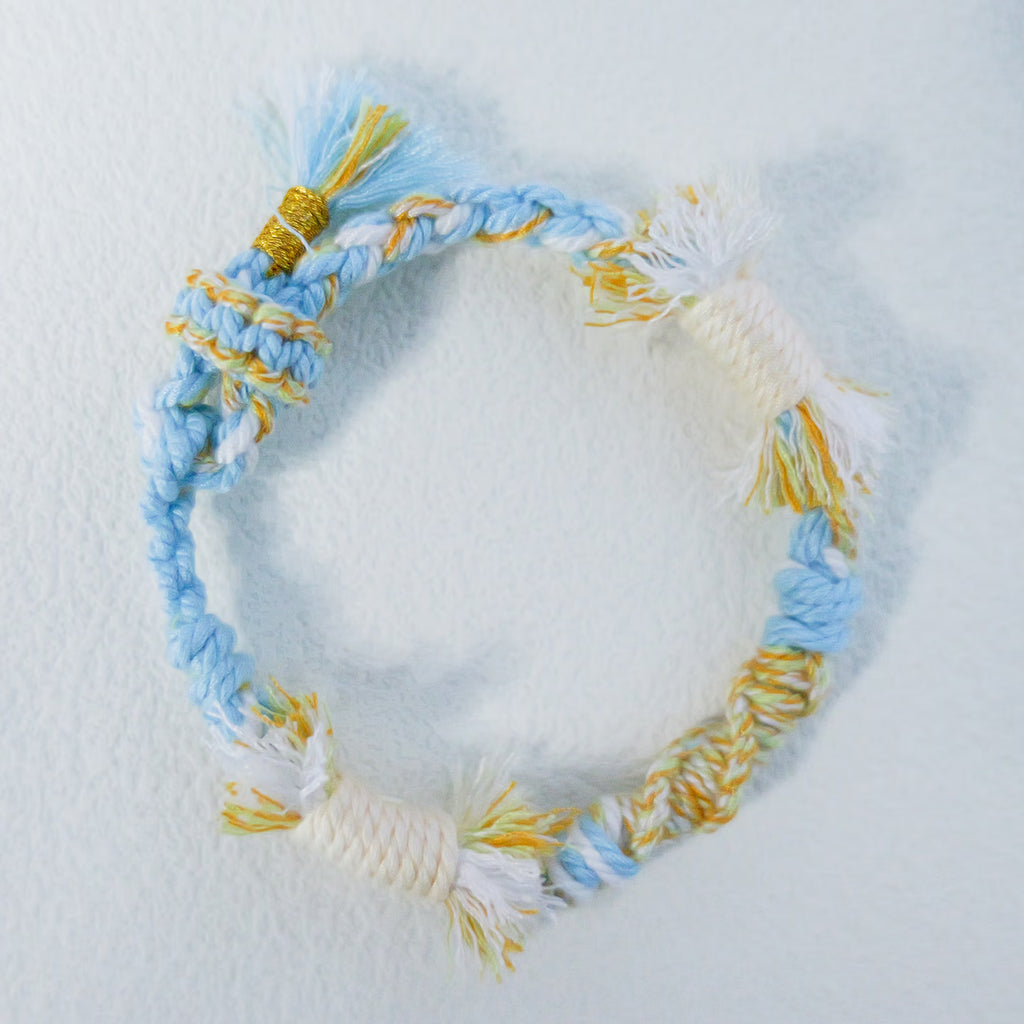 Handmade sky blue, cream and yellow Tibetan braided cord bracelet with fringe detail