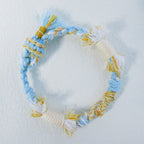 Handmade sky blue, cream and yellow Tibetan braided cord bracelet with fringe detail