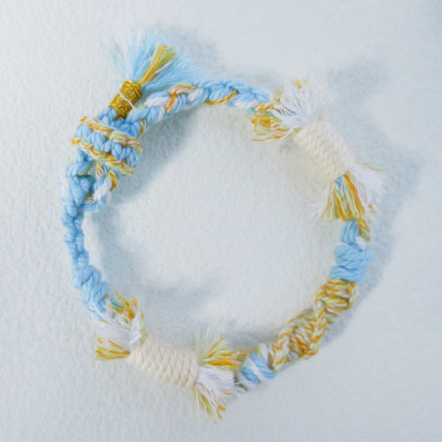 Handmade sky blue, cream and yellow Tibetan braided cord bracelet with fringe detail