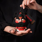 Handcrafted Zhong Kui demon slayer plush herbal sachet pendant with black beard and braided lanyard held in hands