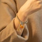 Handmade Tibetan braided cord bracelet with glowing amber stone pendant