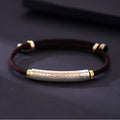 English: S999 fine silver Heart Sutra curved tube bracelet with gold gilded calligraphy on dark braided cord
