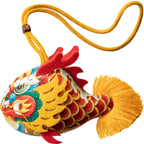 Smiling girl holding a handmade cute silk dragon carp sachet pendant with red blessing tag