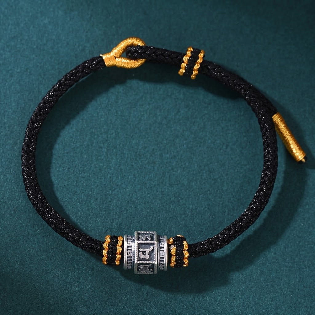 S999 fine silver Six-Syllable Mantra rotating bead on black hand-woven cord with gold accents