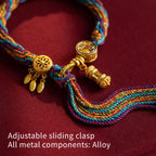 Close up of golden Tibetan prayer wheel charm on colorful woven string bracelet