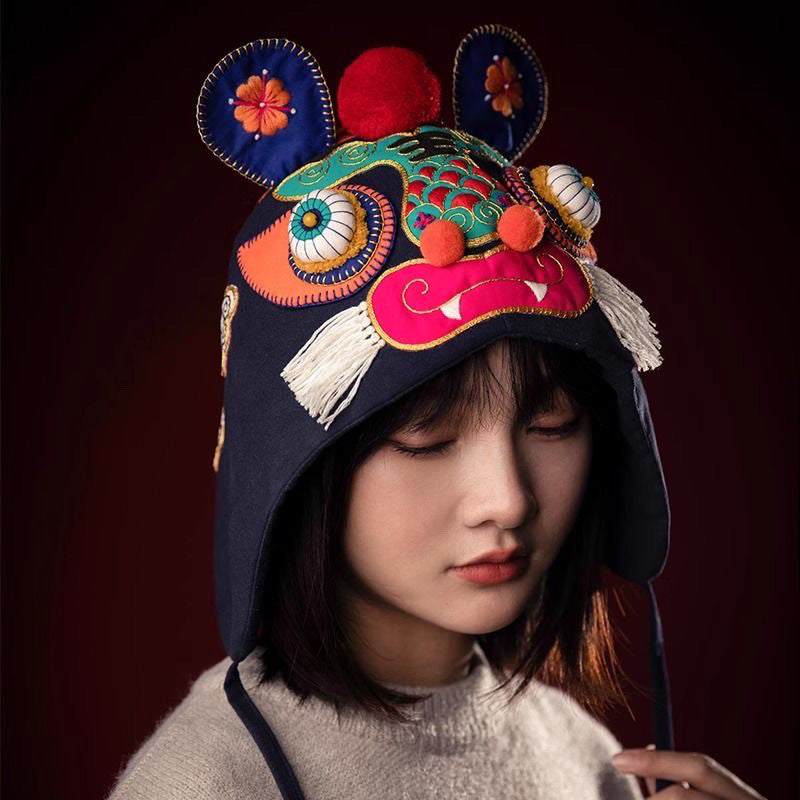Close up of vibrant hand-embroidered tiger face features and cotton ear flaps on traditional folk hat