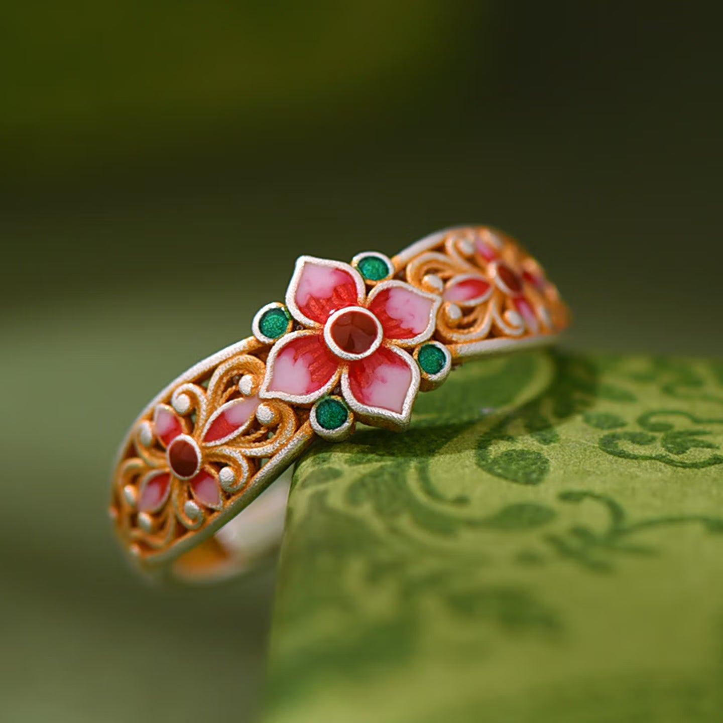 Close up of hand-applied enamel paint inlay on adjustable silver floral ring band