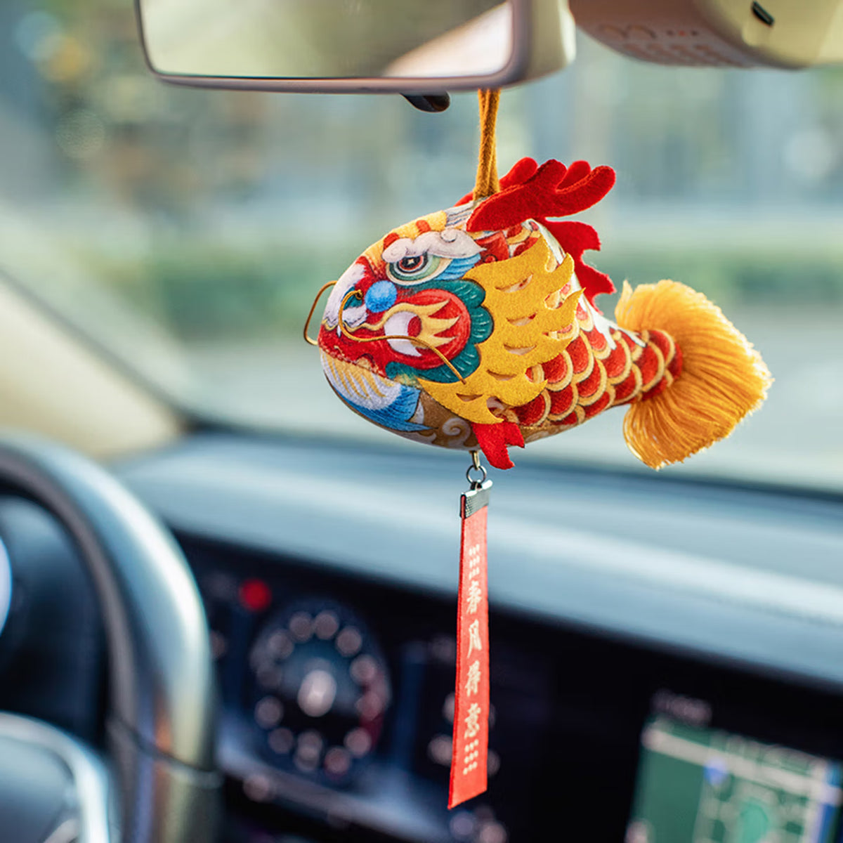 Smiling girl holding a handmade cute silk dragon carp sachet pendant with red blessing tag