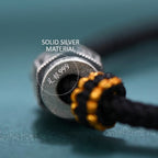 S999 fine silver Six-Syllable Mantra rotating bead on black hand-woven cord with gold accents