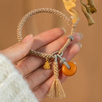 Close up of hand-knotted ethnic cord weave and polished yellow amber pendant charm