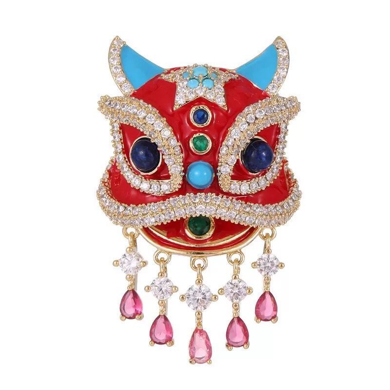Close up of red enamel and faux rhinestone details on oriental lion dance suit lapel pin