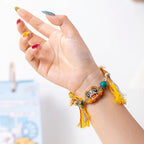 Close up of vibrant embroidered cat charm and hand-knotted cotton polyester cord on ethnic folk art bracelet