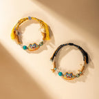 Close up of vibrant embroidered cat charm and hand-knotted cotton polyester cord on ethnic folk art bracelet