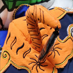 Close up of vibrant hand-embroidered tiger face features and cotton ear flaps on traditional folk hat