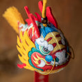 Smiling girl holding a handmade cute silk dragon carp sachet pendant with red blessing tag