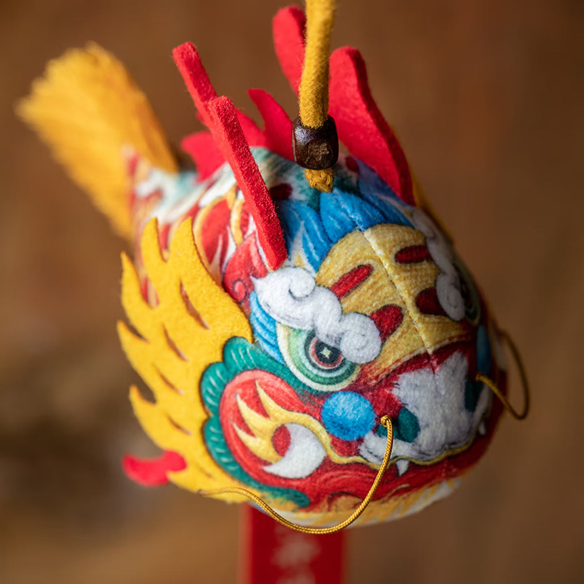 Smiling girl holding a handmade cute silk dragon carp sachet pendant with red blessing tag